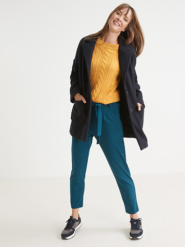 Look d’automne avec le manteau esprit caban pour femme associé à un pantalon élastiqué turquoise et son pull jaune pour femme ronde.